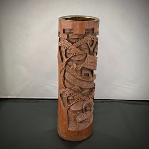 Puede incluir: Un jarrón de madera tallada con un diseño detallado de un barco y árboles. El jarrón es marrón y tiene un acabado de madera natural.