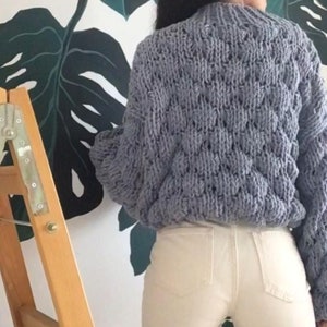 Pu&ograve; includere: Un maglione di lana grossa di colore azzurro chiaro con un motivo testurizzato. Il maglione ha maniche lunghe e una vestibilit&agrave; comoda.