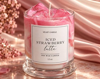 May include: A 12 oz soy wax candle in a clear glass jar with a white label reading VELVET CANDLE ICED STRAWBERRY latte SOY WAX CANDLE 12 oz. The candle features pink and white marbled wax topped with clear, ice-like wax cubes and a single wick.