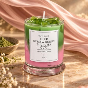 May include: A 12 oz soy wax candle in a clear glass jar with a layered pink and green appearance, topped with green wax ice cubes. The white label reads VELVET CANDLE ICED STRAWBERRY MATCHA latte SOY WAX CANDLE 12 oz.