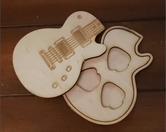 May include: A wooden cutout of an electric guitar with a blank body and a detailed fretboard. The guitar is laying on top of a wooden cutout of a guitar body with three holes for pickups.