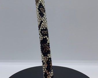 May include: A black, gold, and white rhinestone pen with a leopard print design.