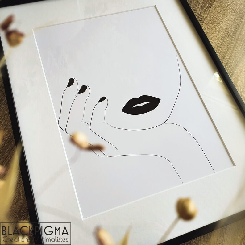 May include: Black and white line art print of a woman's face with bold black lips and a hand resting on her chin. The print is framed in a black frame.
