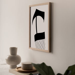 May include: A black and white abstract art print in a wooden frame. The print features a stylized figure with a geometric pattern.