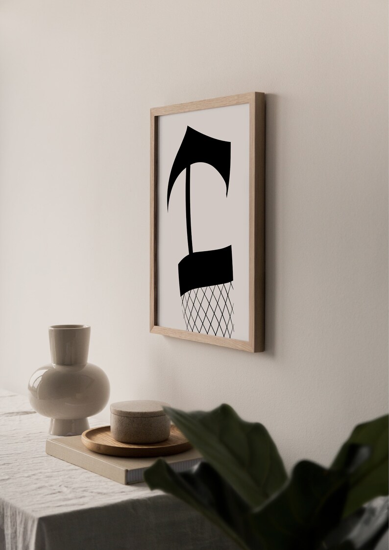 May include: A black and white abstract art print in a wooden frame. The print features a stylized figure with a geometric pattern.