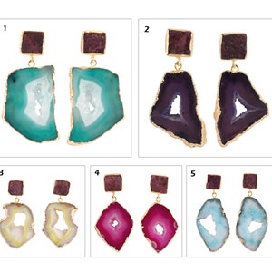 May include: Five pairs of gemstone earrings. Each pair has a square, dark red top stone and a larger, irregularly shaped bottom stone in various colours: teal, purple, yellow, pink, and light blue. The edges of the bottom stones are trimmed in gold.