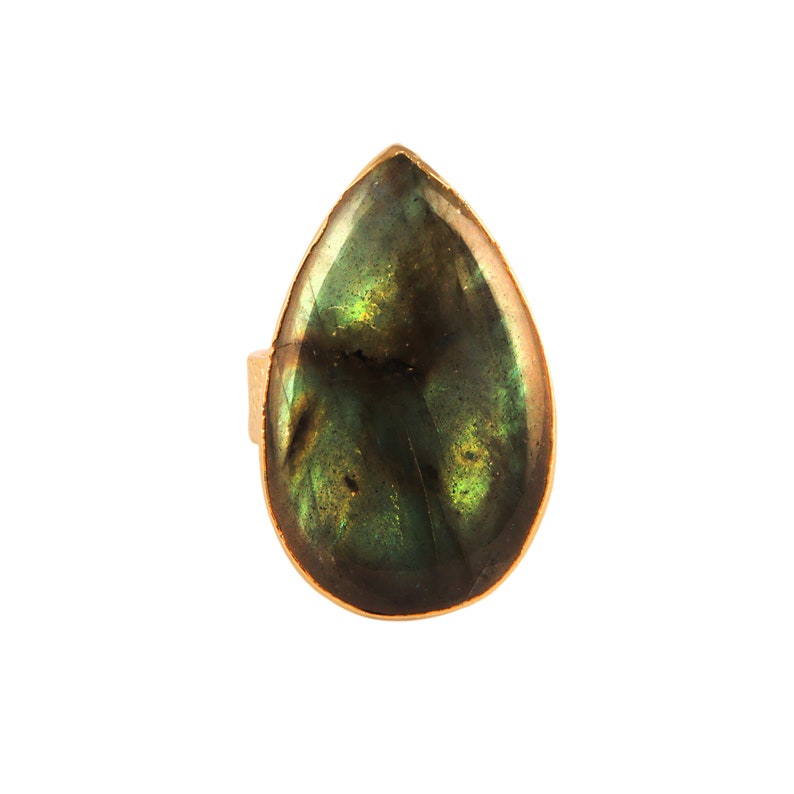 Puede incluir: Un anillo en forma de l&aacute;grima con una piedra preciosa de labradorita verde y dorada.