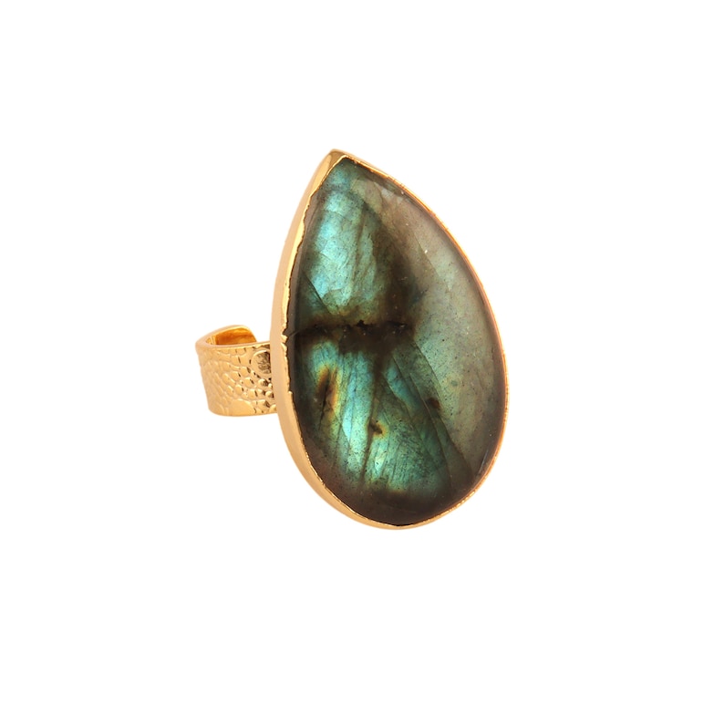 Puede incluir: Anillo de oro con una piedra preciosa de labradorita en forma de l&aacute;grima. La piedra preciosa es de color verde oscuro y gris con destellos iridiscentes.