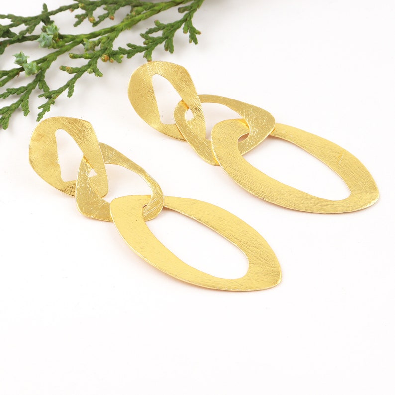 May include: Gold-toned dangle earrings with a chain-link design. Each earring features three oval-shaped links.