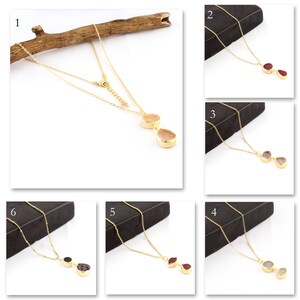 Op de afbeelding: Tien gouden kettingen met verschillende edelsteen hangers. Elke ketting heeft twee hangers in de vorm van een traan.