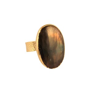 Puede incluir: Un anillo de oro con una gran piedra ovalada de labradorita. El anillo tiene una banda texturizada.