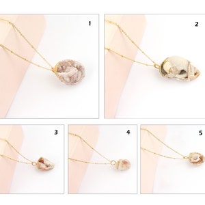 May include: A collection of five gold-toned necklaces, each featuring a unique, raw geode or crystal pendant. The delicate gold chains are attached to the natural, textured stone pieces, which vary in shape, size, and crystalline structure.