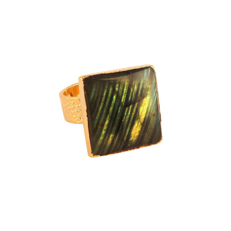 Puede incluir: Un anillo de oro con una piedra cuadrada verde y dorada.