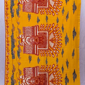 Peut inclure: Un tissu jaune vif avec un motif répété de figures stylisées et d'éléments décoratifs. Le motif présente des figures rouges et blanches avec des accents de plumes, des formes de diamants noirs et des bordures florales. Le tissu est probablement utilisé pour les vêtements ou la décoration intérieure.