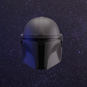 Pode incluir: Um capacete cinza com uma viseira preta e um tom azul escuro. O capacete tem uma parte superior lisa e arredondada e uma seção inferior texturizada e angular. O capacete está colocado sobre um fundo azul escuro com estrelas brancas.