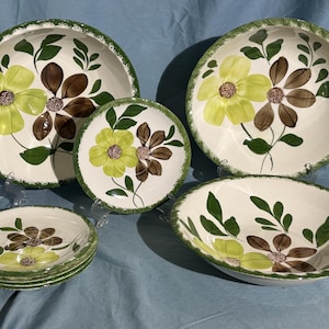 May include: Set of five vintage floral patterned ceramic bowls in shades of green, brown, and yellow. The bowls are in various sizes and feature a floral design with green leaves and brown and yellow flowers.