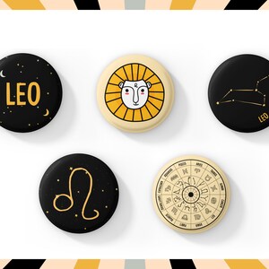 May include: Five circular badges with Leo-themed designs. The badges feature a lion illustration, the word "LEO" with stars, a constellation, and a zodiac wheel. The colour scheme includes black, gold, and cream.