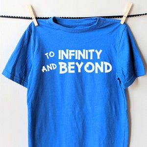 May include: A blue t-shirt with white text that reads "To Infinity and Beyond".