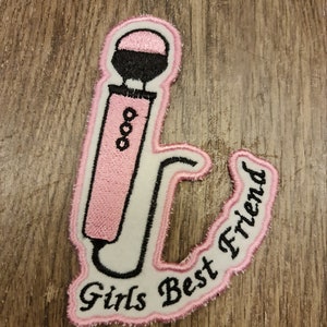 May include: Pink and white embroidered patch with a microphone design and the text "Girls Best Friend".