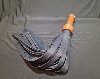 Edgyyyyy Designs black calfskin leather flogger with hardwood handle and hot foiled leather end cap