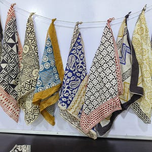 May include: Eight different fabric squares with black and white geometric patterns, some with a yellow border, some with a red border, and one with a blue border.