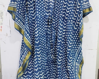 May include: A blue and white patterned kaftan with a V-neck and short sleeves. The fabric features a repeating pattern of white dots and chevron shapes. Gold trim accents the edges of the sleeves and hem.
