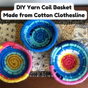 May include: Three round coil baskets made from cotton clothesline wrapped in colorful yarn. One basket features shades of blue, another yellow and pink, and the third pink, blue, and yellow. Text reads: DIY Yarn Coil Basket Made from Cotton Clothesline.