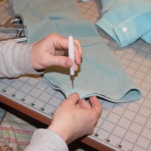 Step photo from tutorial showing poking hole with awl.