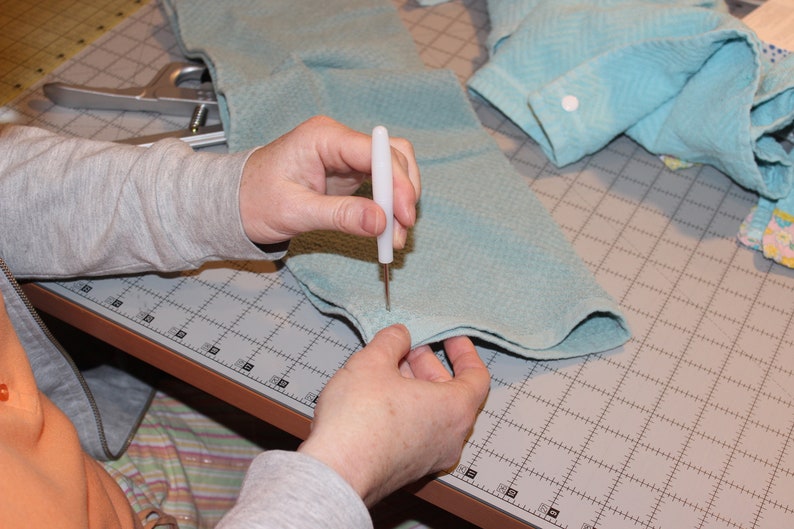Step photo from tutorial showing poking hole with awl.