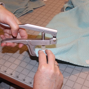 Step photo from tutorial, showing kam snap pliers.