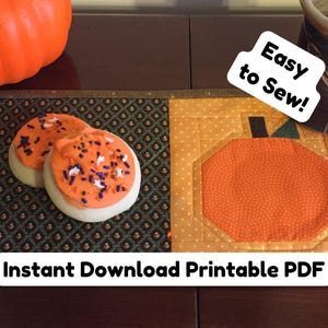Puede incluir: Un patrón PDF imprimible para una posavasos acolchado con forma de calabaza. El posavasos es naranja con un tallo marrón y está rodeado por un borde marrón. El texto "¡Fácil de coser!" está escrito en un bocadillo de diálogo blanco. El texto "Descarga instantánea PDF imprimible" está escrito en una pancarta blanca.