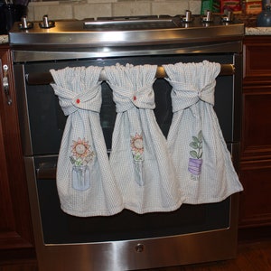 Herb towels with Kam snaps hanging on stove handle.