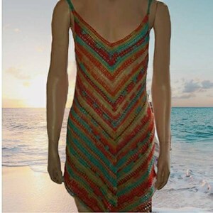 May include: A colorful crochet dress with a chevron pattern in shades of orange, red, green, and blue. The dress is sleeveless and has a V-neckline.