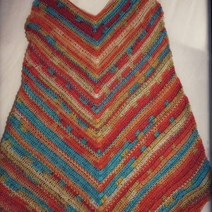 May include: A crocheted top with a V-neck and thin straps. The top is made with a multi-colored yarn in shades of orange, blue, green, and beige. The top is crocheted in a striped pattern.