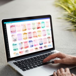Peut inclure: Un ordinateur portable affichant une grille de fonds aquarelle. Les fonds sont dans diff&eacute;rentes nuances de rose, bleu, vert et jaune. L'ordinateur portable est ouvert et une main est plac&eacute;e au-dessus du clavier.