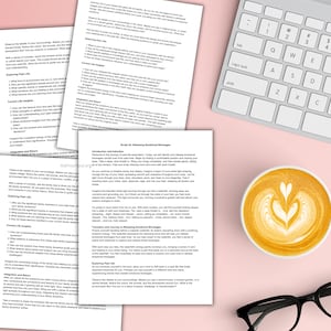 May include: A close-up of a printed page with the title "Script 28: Releasing Emotional Blockages" and text about releasing emotional blockages. The page is on a pink surface with a white keyboard and a cup of coffee.