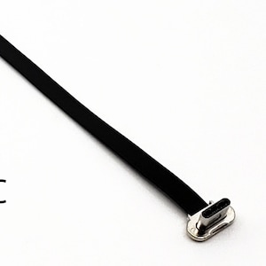 May include: A black USB 2.0 to USB-C cable with a rectangular USB 2.0 connector and a USB-C connector. The text "USB 2.0 to USB-C" is printed in black on a white background.