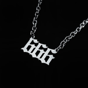 May include: A silver chain necklace with a pendant featuring the number 666 in a gothic font.