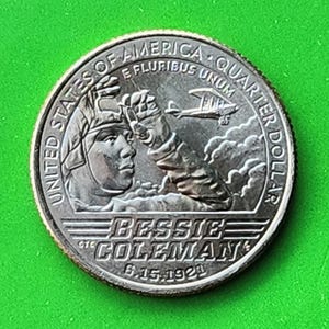 Può includere: Una moneta da un quarto di dollaro americano in argento con il ritratto di Bessie Coleman, la prima donna afroamericana ad ottenere una licenza di pilota, con il testo "Bessie Coleman 5-15-1921" e "United States of America E Pluribus Unum Quarter Dollar".