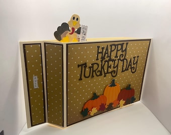 May include: Thanksgiving-themed pop-up card with a turkey and pumpkins. The card features the text "Happy Turkey Day" and a pull tab. The card is decorated with a polka dot pattern and autumn leaves.