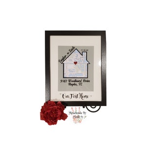 May include: A framed print with a map of a neighborhood in the shape of a house. The house is decorated with a red heart and the text "Taylor Zach 11.16.20 9142 Woodhurst Drive Naples, FL Our First Home Handmade By Heidi D".