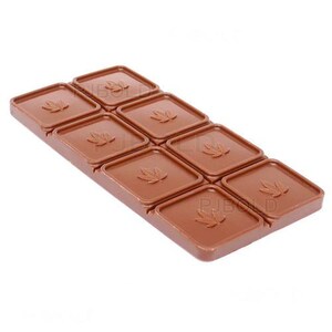 May include: A brown, rectangular chocolate bar with eight square sections. Each section features a raised maple leaf design. The bar is a solid color and appears to be made of a hard material.