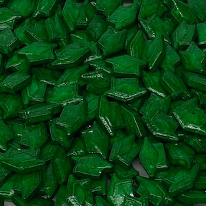 May include: A large quantity of green graduation cap shaped sprinkles. The sprinkles are shiny and have a slightly raised texture.