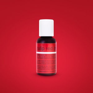 May include: A small bottle of red food coloring labeled "tulip red (r)". The bottle is on a red background.