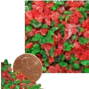 May include: Close-up of red and green candied fruit pieces, with a penny for scale. The colorful, diced pieces are scattered, with a focus on the vibrant textures and hues. The penny shows the year 2018.