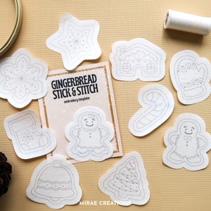 May include: A set of ten white gingerbread stick and stitch embroidery templates. The templates feature various Christmas designs, including a gingerbread person, a star, a candy cane, a stocking, a bell, a tree, a snowflake, and a gingerbread house. The templates are printed with "Gingerbread Stick & Stitch" and "Embroidery Templates" on a card.