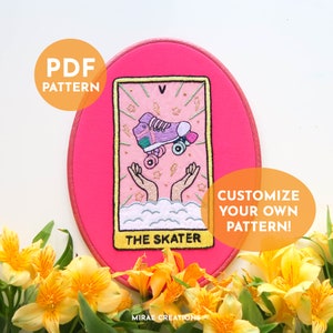 Könnte beinhalten: Ein pinkfarbener, ovaler Stickrahmen mit einem Tarotkarten-Design, das einen Rollschuh zeigt. Die Karte trägt die Aufschrift "The Skater" und enthält den Text "PDF PATTERN" und "CUSTOMIZE YOUR OWN PATTERN!" Das Bild ist von gelben Blumen umgeben.