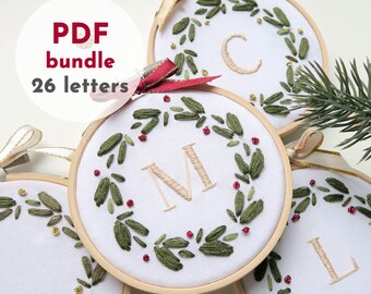 Pode incluir: Um conjunto de 26 padrões de bordado para enfeites de Natal com uma coroa de folhas verdes e bagas vermelhas com uma única letra no centro. O pacote PDF inclui padrões para todas as letras do alfabeto.