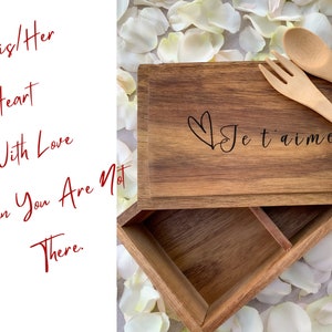 K&ouml;nnte beinhalten: Eine Holzkiste mit einem Herz und dem Text "Je t'aime" auf dem Deckel. Die Kiste hat zwei F&auml;cher und wird mit einem Holzl&ouml;ffel und einer Holzgabel geliefert.