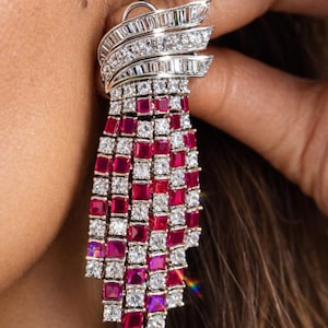 Puede incluir: Elegante pendiente colgante con una cascada de piedras preciosas rojas y blancas de corte cuadrado. La parte superior tiene un diseño en capas con múltiples filas de piedras rectangulares transparentes. Una lujosa pieza de joyería.